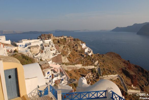 Blick über die weißen Häuser und blauen Kuppeln von Oia, Santorini, auf das Ägäische Meer – ein Symbol für authentisches Reisen.